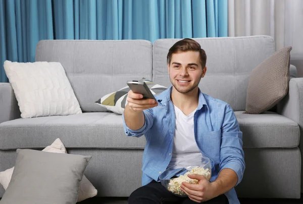 Junger Mann schaut zu Hause fern — Stockfoto