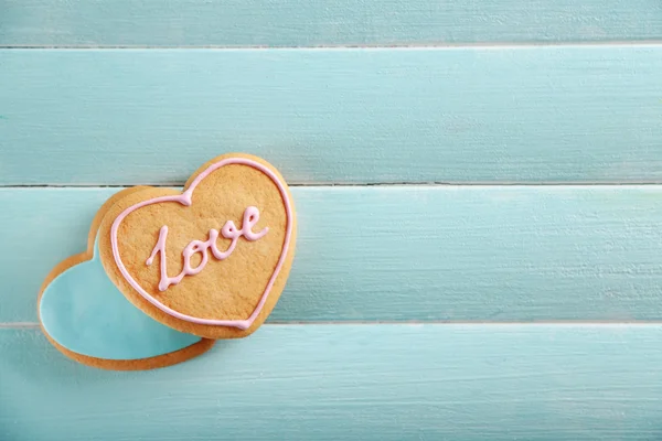 Love cookies on blue wooden table background, copy space
