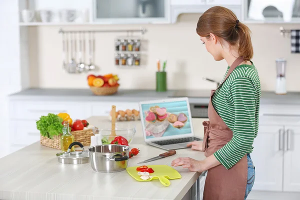 Young woman cooking in kitchen — Stock Photo, Image