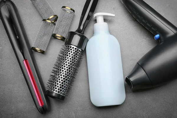 Set de peluquería con herramientas, equipo y cosmética sobre fondo gris — Foto de Stock