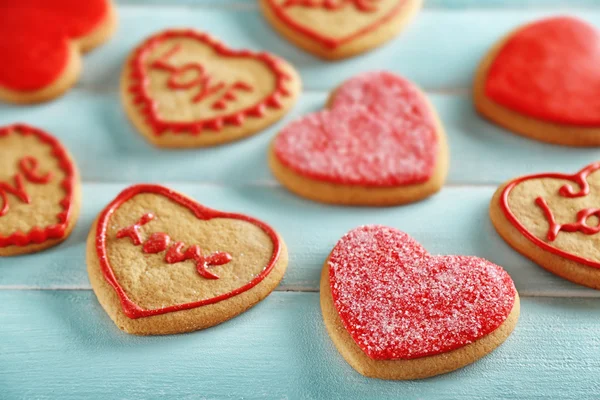 Aşk kurabiyeleri mavi ahşap masa arka plan üzerinde ürün yelpazesine — Stok fotoğraf