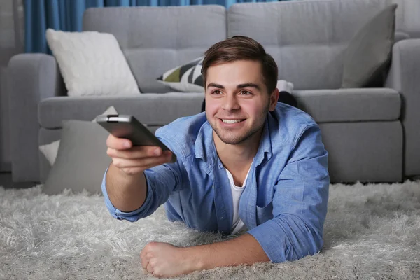Mladý muž kouká doma na televizi — Stock fotografie