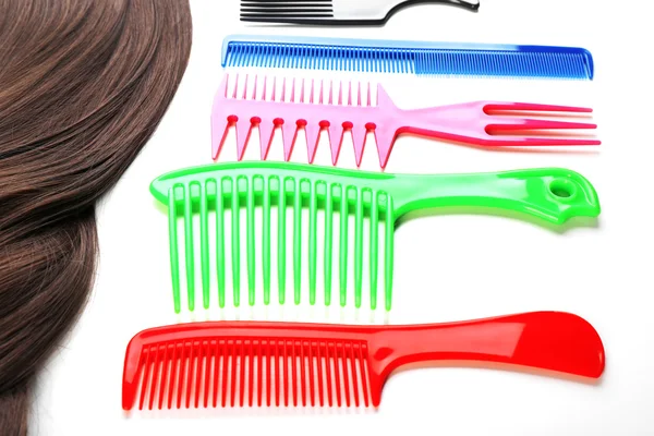 Barber set with strand of hair and different combs, isolated on white — Stock Photo, Image