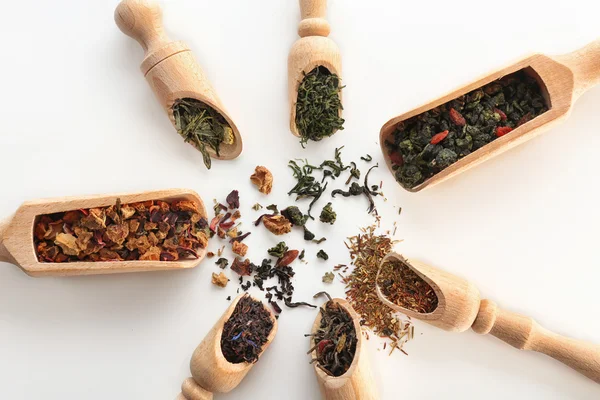 Variedad de té seco en cucharadas de madera aisladas en blanco, vista superior —  Fotos de Stock