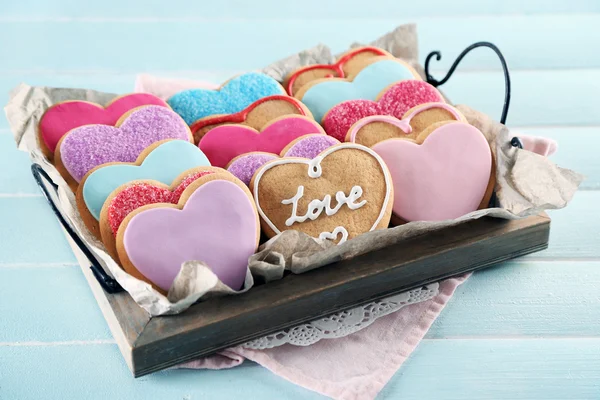 Bandeja con galletas de amor sobre fondo de mesa de madera azul — Foto de Stock