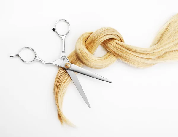 Hairdresser's scissors with strand of blonde hair, isolated on white — Stock Photo, Image