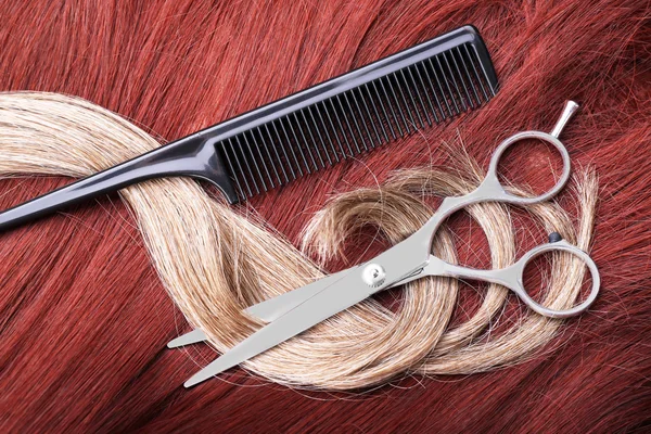 Tijeras de peluquería con peine y mechones de pelo varicolorados, de cerca — Foto de Stock