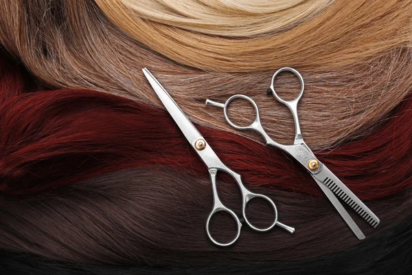 Hairdresser's scissors with varicolored strands of hair, close up — Stock Photo, Image