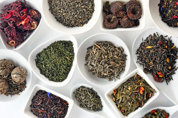 Variety of dry tea in bowls and spoons, closeup — Stock Photo, Image