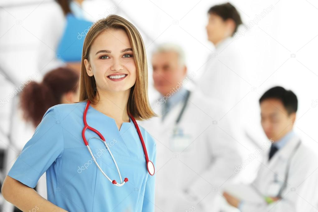 Portrait of doctor in front of colleagues indoors