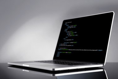 Programlama kodu üstünde laptop 