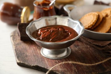 Kase, ahşap arka plan üzerinde eritilmiş çikolata