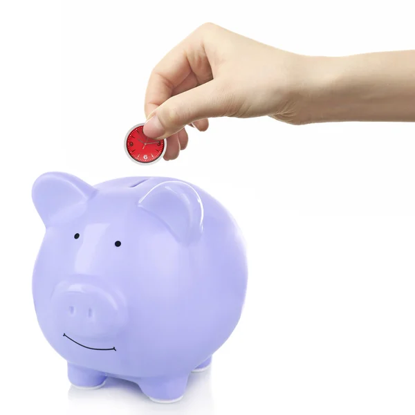 Hand putting closk in piggy bank — Stock Photo, Image