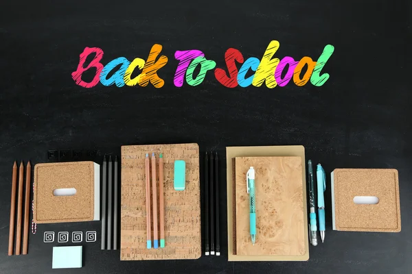 School supplies on blackboard — Stock Photo, Image