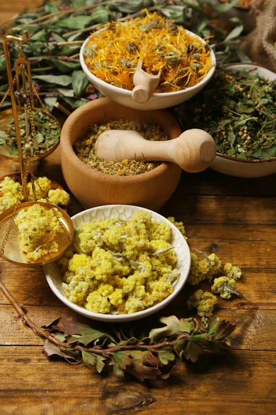 Assortiment d'herbes médicinales sèches dans des bols sur fond bois vue de dessus — Photo