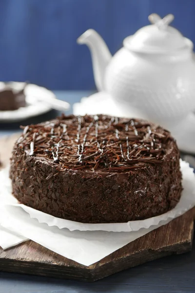 Tasty chocolate cake on color wooden background — Stock Photo, Image