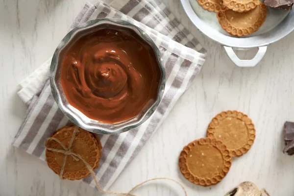 Chocolate derretido en tazón, sobre fondo de madera —  Fotos de Stock