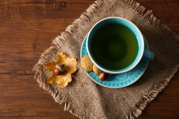 Xícara de chá com decoração de outono na mesa de madeira . — Fotografia de Stock