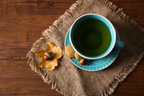 Tasse Tee mit Herbstdekor auf Holztisch. — Stockfoto