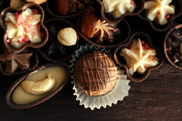 Delicious chocolate candies on wooden background, close up — Stock Photo, Image