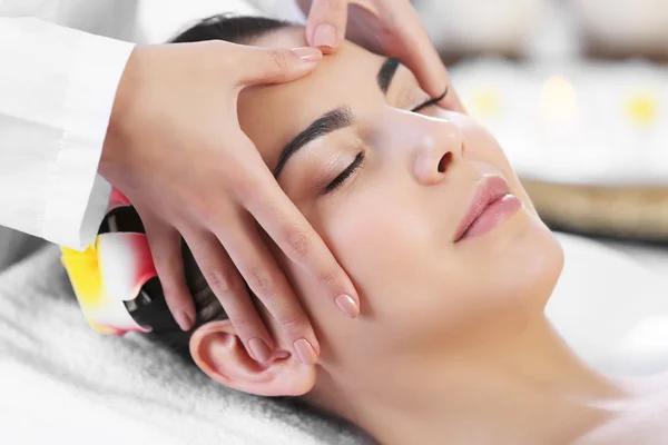 Жінка розслабляється з масажем обличчя — стокове фото