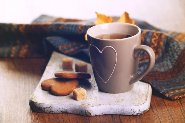 Чашка чая с осенним декором на деревянном столе . — стоковое фото