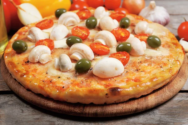 Heerlijke pizza en verse groenten op houten achtergrond, close-up — Stockfoto