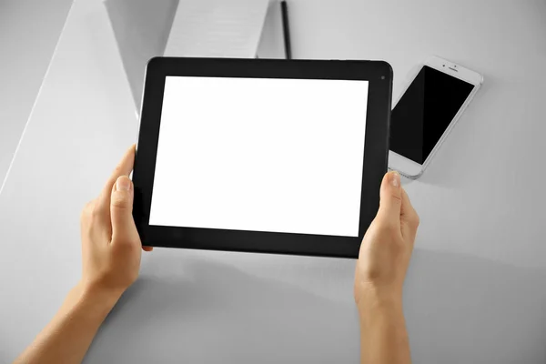 Teléfono móvil y manos femeninas usando tableta moderna, en interiores —  Fotos de Stock