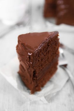 Bir parça çatal ahşap masa arka planda, closeup ile çikolatalı kek