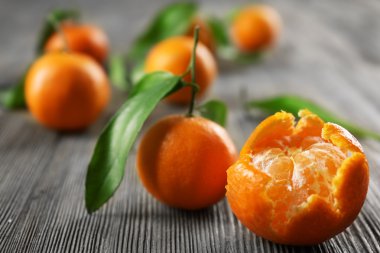 Yaprakları ve ahşap masa, closeup üzerinde olgunlaşmış mandalina ile soyulmuş taze mandalina