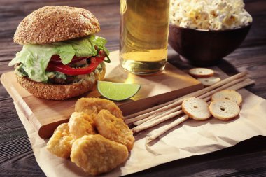 Aperatifler ve ahşap masa üzerinde light bira şişe cam ile büyük lezzetli hamburger