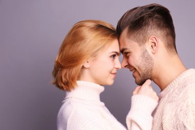 Gri arka plan üzerinde birbirine bakarak aşık genç Çift