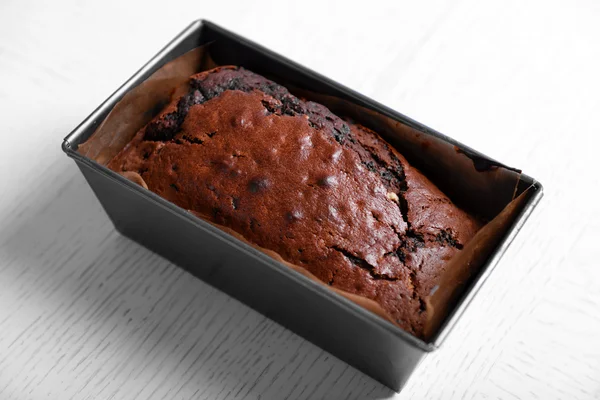 Chocolade taart in ovenschaal op witte tafel — Stockfoto