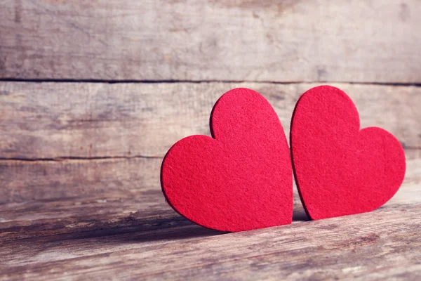 Corazones de fieltro rojo sobre fondo de madera — Foto de Stock