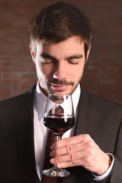 Hombre olfateando vino tinto en copa — Foto de Stock