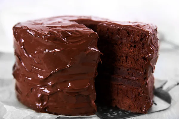 Gâteau au chocolat avec une pièce coupée sur fond de table en bois, gros plan — Photo