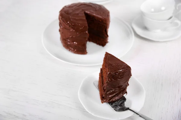 Bolo de chocolate em placas com uma peça de corte em fundo desfocado — Fotografia de Stock