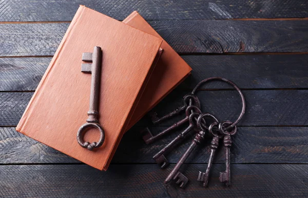 Bunch of old keys with notebooks on dark wooden background, close up — Stock Photo, Image