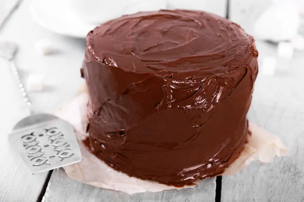 Pastel de chocolate con hoja sobre un fondo de mesa de madera — Foto de Stock