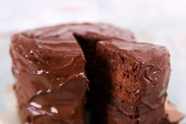 Torta al cioccolato con un pezzo tagliato su sfondo tavolo di legno, primo piano — Foto Stock