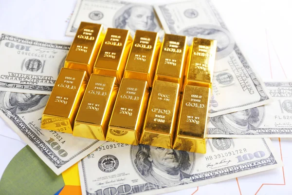 Barras de oro con billetes de dólar sobre fondo de papel — Foto de Stock