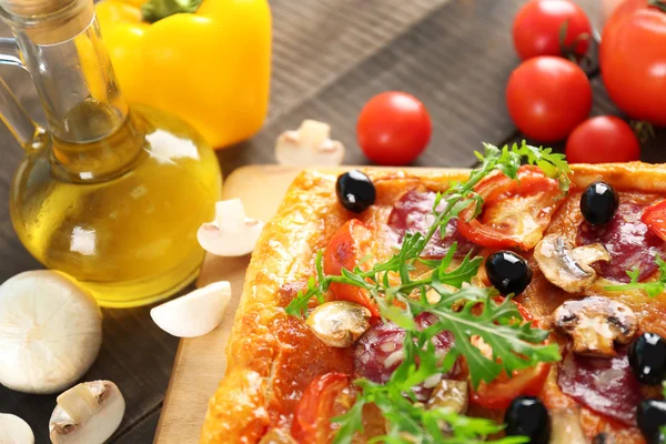 Téglalap finom pizza és zöldség az asztalra, közelkép — Stock Fotó