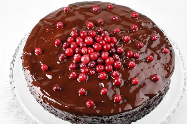 Bolo de chocolate com cranberries em placa de vidro, close-up — Fotografia de Stock
