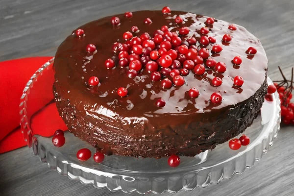 Schokoladenkuchen mit Preiselbeeren auf Holzgrund — Stockfoto