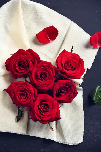 Fresh red roses buds in shape of heart with linen fabric on black textured background — Stock Photo, Image