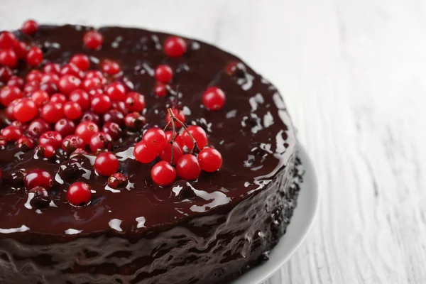 Chocolate cake with cranberries on white wooden table, closeup — Stock Photo, Image