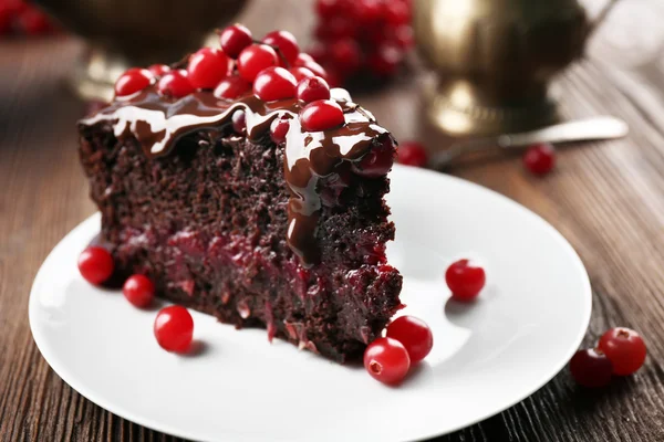 Stück Schokoladenkuchen mit Preiselbeeren auf Holztisch, Nahaufnahme — Stockfoto