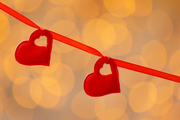 Hängande Valentines hjärtan på suddig ljus bakgrund — Stockfoto