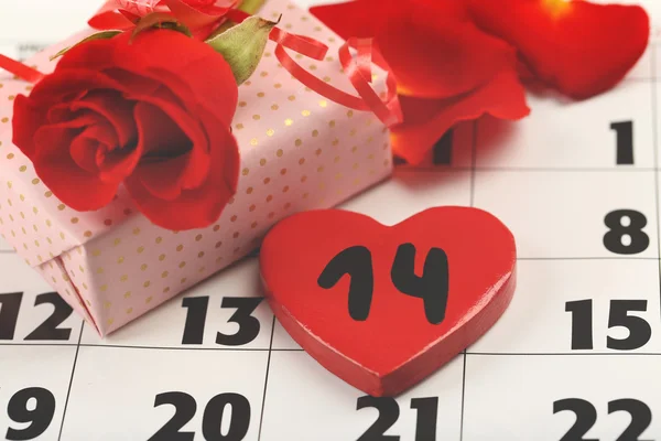 Kalender med datum för februari 14, presentförpackning och rosa blomblad. Alla hjärtans dag koncept — Stockfoto