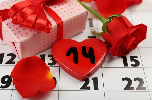 Kalender met datum van 14 februari geschenkdoos en roze bloemblaadjes. Valentines day concept — Stockfoto